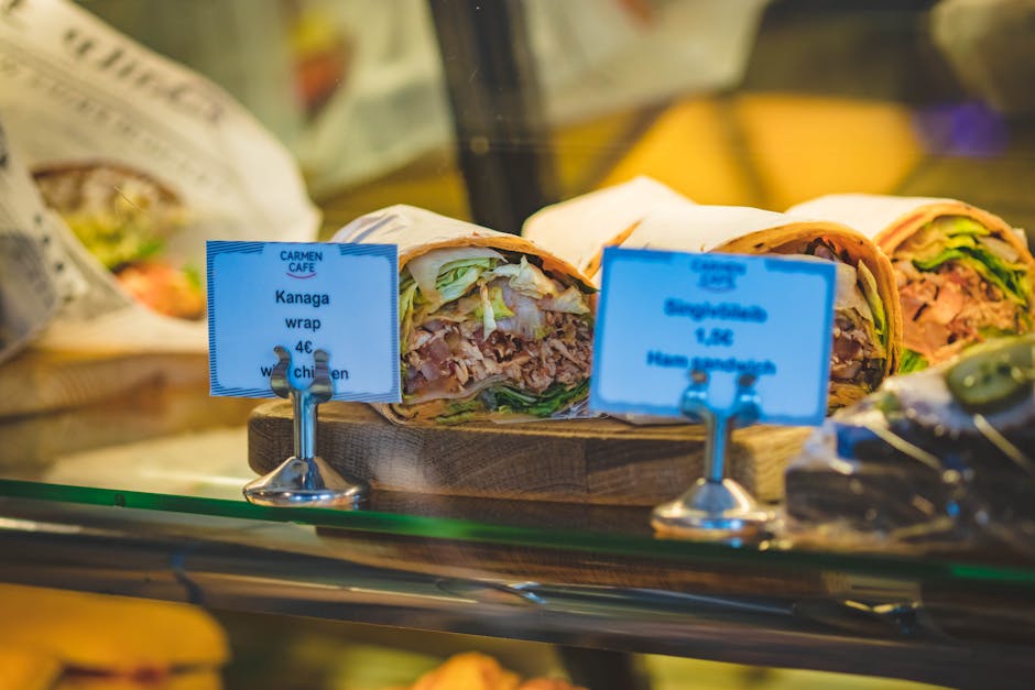 Fresh and tasty Kanaga wraps with chicken and ham displayed at a cafe counter.