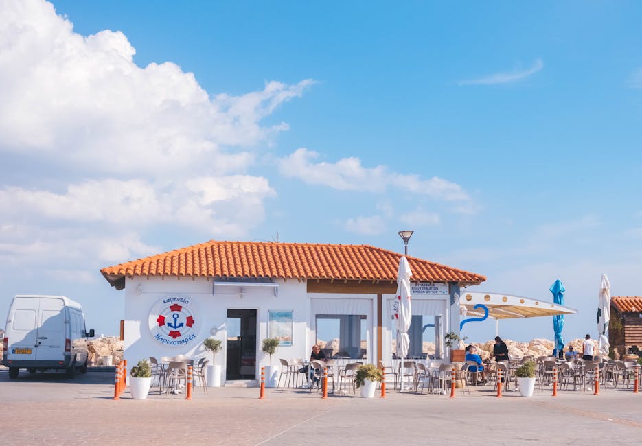 A cozy seaside cafe with outdoor seating under a bright blue sky in Cyprus.