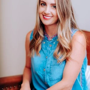 Professionele foto van een lachende vrouw met blond haar in een blauwe blouse.
