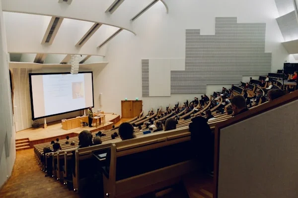 Een collegezaal gevuld met studenten die een presentatie volgen.