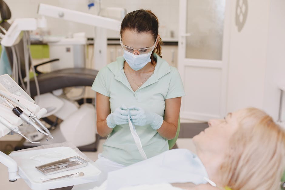 Een tandarts bereidt zich voor op een behandeling met een patiënt in de stoel.