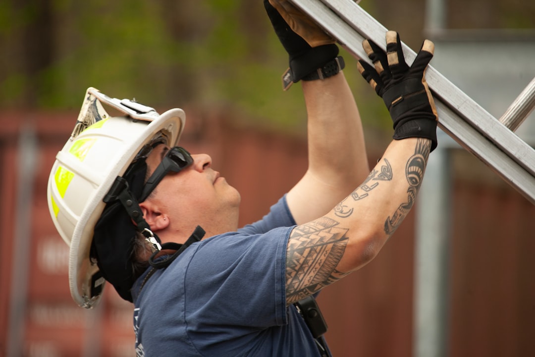 Firefighter in helmet adjusts metal scaffolding outdoors